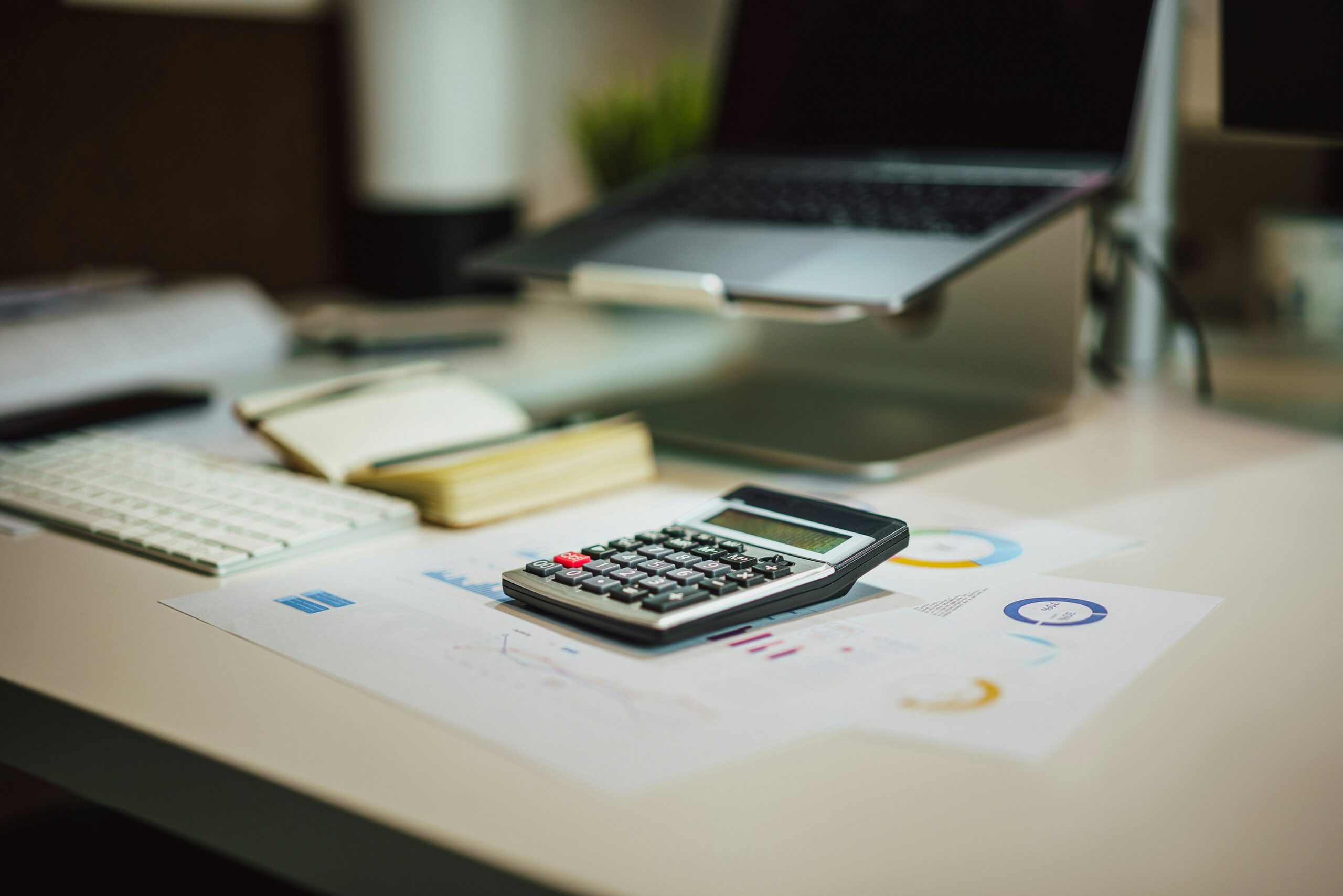 Calculator and laptop on a desk, working out how much to set aside for BAS