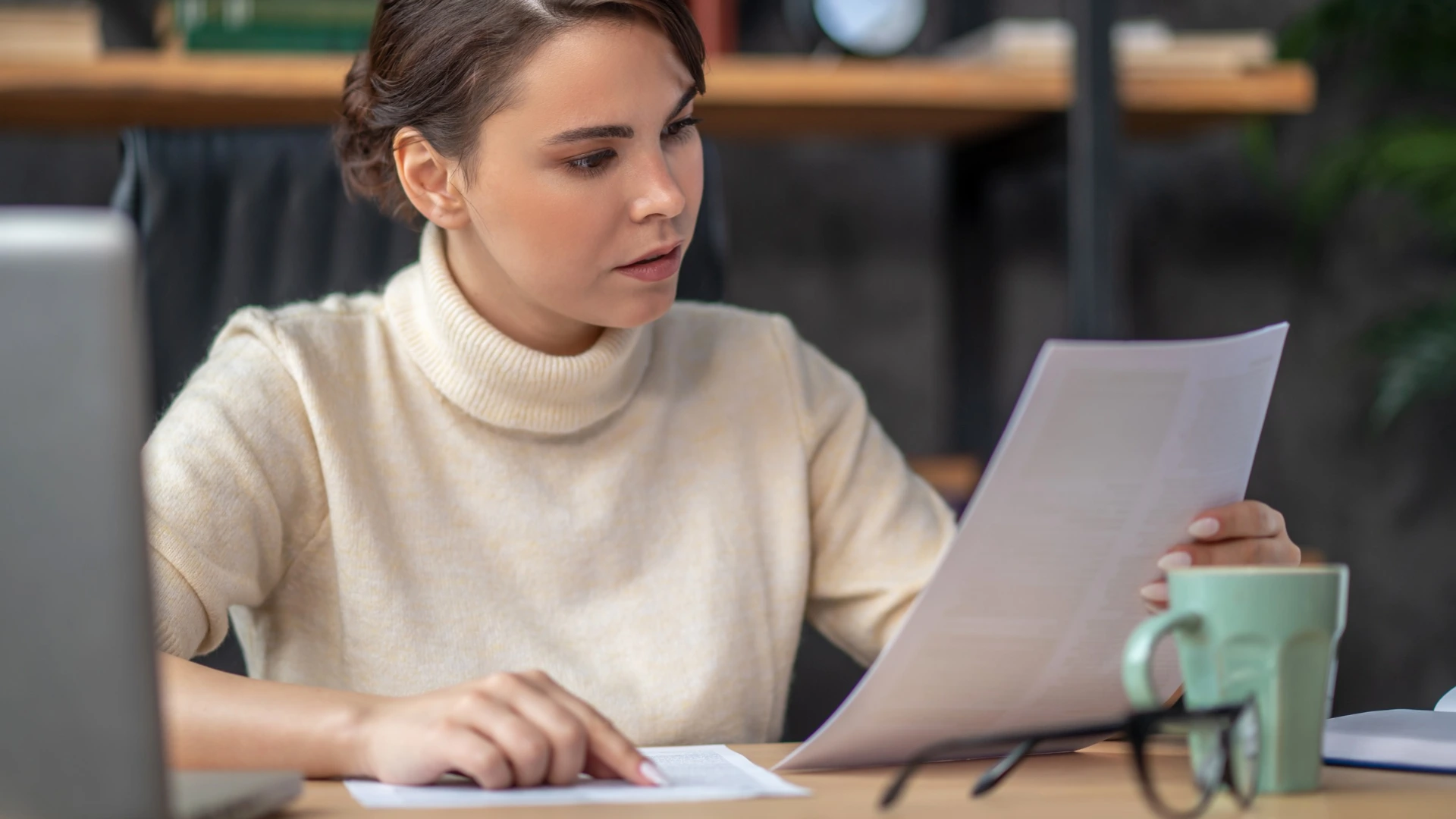 Getting paid on time when your customers’ wallets are shrinking A woman going through her invoices to check if she's getting paid on time.